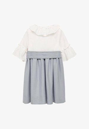 Biała bluzka z falbankowym kołnierzykiem i krótkimi rękawami, zestawiona z niebieską spódnicą o kroju litery A z plisami. Materiał z bawełnianej mieszanki, gładka faktura.