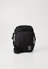 Melna plecu soma no izturīgas auduma ar struktūrētu virsmu. Aprīkota ar logotipa plāksteri, regulējamu siksnu un rāvējslēdzēja galveno nodalījumu.