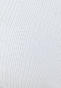 Weißer gerippter Stoff mit einem strukturierten Muster, das vertikale Linien und kleine Akzente zeigt, wodurch ein subtiler, gemusterter Effekt entsteht.