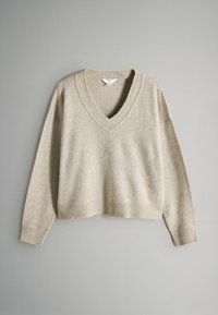 Beiger V-Ausschnitt-Pullover aus weichem Material mit überschnittenen Schultern und gerippten Details an Kragen und Saum, erhältlich im cropped Design.