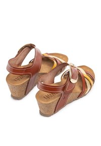 Bruine leren wedge sandalen met meerdere banden en gele en gouden accenten. Kurken zool en gevoerde binnenzool voor comfort.