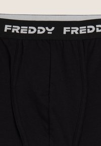Boxer in cotone nero con una fascia larga nera in vita con il nome del marchio "FREDDY" stampato in bianco. Texture morbida, design semplice.