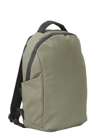 Mochila verde oliva con un acabado mate y suave. Cuenta con un asa superior, correas de hombro acolchadas y un bolsillo lateral para almacenamiento adicional.