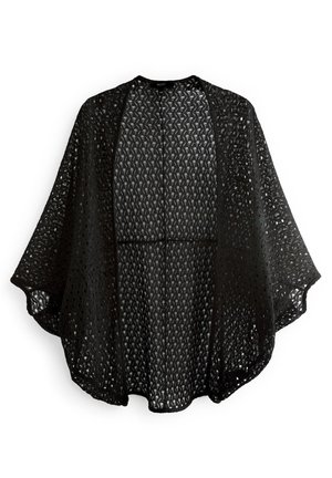Cardigan en dentelle noire avec ouverture devant, manches larges et motifs géométriques complexes, léger et semi-transparent.