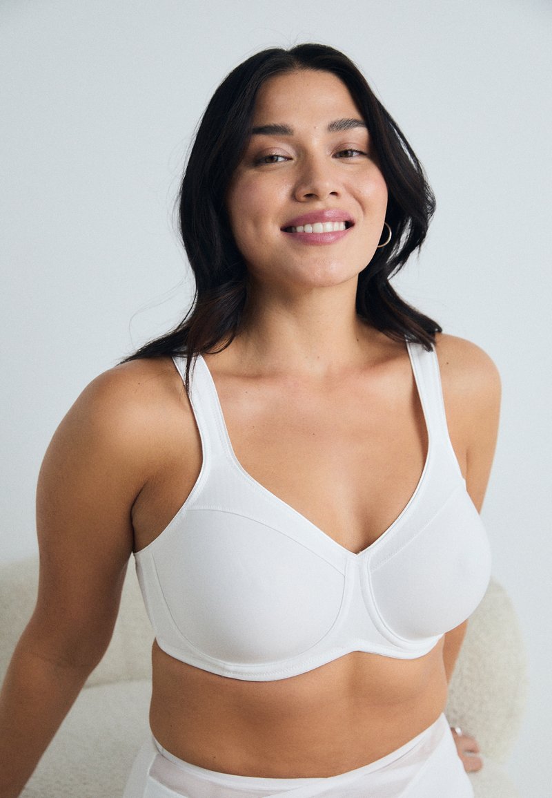White bra with adjustable straps, smooth fabric and molded cups. Features seam detailing and soft texture, designed for comfort and support.