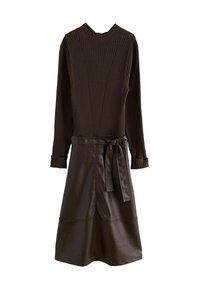 Ruskea ribbattu neulepaita, jossa on korkea kaulus, pitkät hihat ja vyölaukulla varustettu ruskea nahkahame, jossa on levenevä helma. Sileä rakenne ja muotoiltu design.