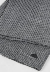 Pilka ribota šalikėlis, pagamintas iš minkštos, tekstūruotos megztos medžiagos. Krašte yra trikampė juoda logotipo etiketė.