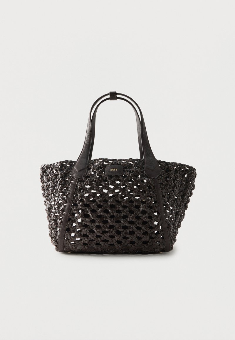 Μαύρη υφαντή δερμάτινη τσάντα tote με διπλές λαβές και μικρό ορθογώνιο σημάδι λογότυπου στο κέντρο πάνω μέρος.