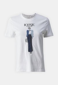Bílý bavlněný tričko se grafickým designem módní postavy v modré bundě a tmavých kalhotách, s textem "IKONICKÝ."