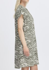 Šaty s krátkym rukávom v olivovo zelenej farbe a bielymi zebra pruhmi, z ľahkého materiálu, vo voľnom strihu, po kolená, s okrúhlym výstrihom.