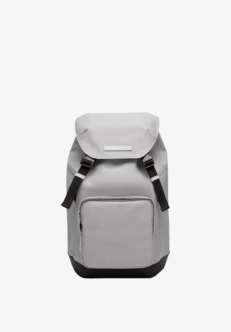 Sac à dos en tissu gris avec une fermeture enroulable, fond noir, bretelles ajustables, poche éclair à l'avant et onglet décoratif subtil.