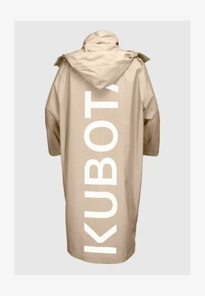 Beżowy, wodoodporny, oversize'owy płaszcz z kapturem. Ma na plecach dużą, białą napis "KUBOTA" w pionie. Gładki, trwały materiał.