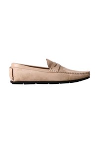 Mocassin homme en daim beige avec un design sans lacets et une semelle en caoutchouc noir, présentant une bride cousue sur le dessus.