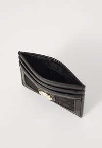 Portafoglio in pelle nera con finitura liscia, dotato di hardware dorato, quattro scomparti per carte e una tasca aperta. Dettaglio design testurizzato sul frontale.