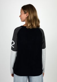 Navy, gray, and light gray color-blocked knit sweater with long sleeves. Features a relaxed fit and a rounded neckline.