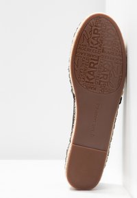Semelle d'une espadrille taille 37 avec un dessous en caoutchouc texturé, affichant en répétition la marque "KARL LAGERFELD" et la signature.