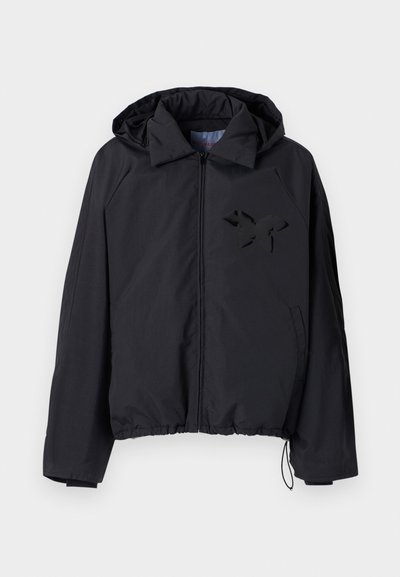 Jachetă neagră tip windbreaker cu fermoar în față, glugă, tiv elastic și un logo texturat de fluture negru pe partea stângă a pieptului.