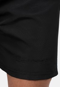 Pantaloni corti neri realizzati in tessuto morbido, con un discreto logo ricamato all'orlo. Design semplice con taglio dritto.