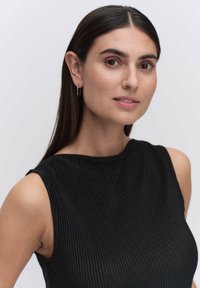 Svart ribbad ärmlös topp med en texturerad yta, med hög halsringning och släta kanter. Små silverfärgade hoops.