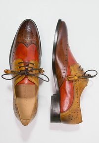 Kožené boty s kombinací oranžových, hnědých a žlutých odstínů. Klasick�ý brogue design s perforacemi a šněrováním. Plná černá podešev.