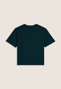 Camiseta de manga corta verde oscuro vista desde atrás sobre un fondo beige liso, con un cuello redondo y un estilo simple.