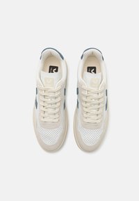 Witte sneakers met blauwe accenten, geperforeerde neus, suède details en platte veters. Beschikt over een logo op de tong en een gestructureerde rubberen zool.