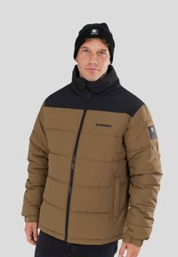 Puffer jacket in brown with black accents, featuring a high collar, zip front, side pockets, and a logo on the chest and sleeve.