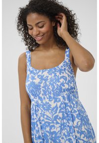 Blau-weißen gemusterte Kleid mit quadratischem Ausschnitt und breiten Trägern, das einen lässigen Schnitt und einen strukturierten Stoff aufweist.