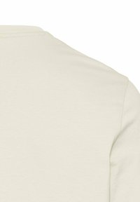 Lys beige kortærmet t-shirt, blødt bomuldsstof, rund hals, glat tekstur, minimalistisk design uden synlige mønstre eller accenter.