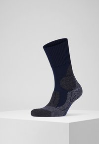 Marineblaue Socke mit geripptem Bündchen, strukturiertem Fußbett und verstärktem Zehen- und Fersenbereich. Akzentuiert mit einem kontrastierenden dunkleren Muster.