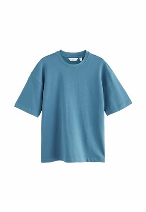 Camiseta de manga corta en suave algodón azul. Presenta un escote redondo y un ajuste relajado con hombros caídos. Sin patrones ni adornos visibles.