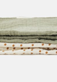 Quattro pezzi di tessuto: due di un verde opaco testurizzato e due crema con pois marroni, impilati ordinatamente per mostrare i loro motivi e colori.