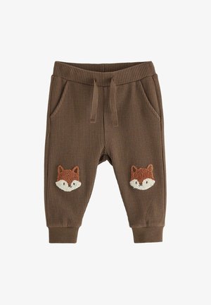 Bruna, strukturerade sweatpants med ett elastiskt midjeband och två sidofickor. Har broderade rävansikten på varje lår.