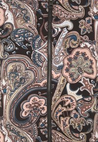 Tela negra con un patrón de cachemira en rosa, azul y crema. Presenta una cremallera central y diseños florales intrincados por todo el tejido.