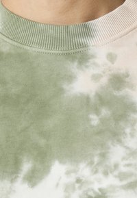 Sudadera de tie-dye verde con cuello acanalado y una tela suave y texturizada, con variaciones de color en verde claro y oscuro.