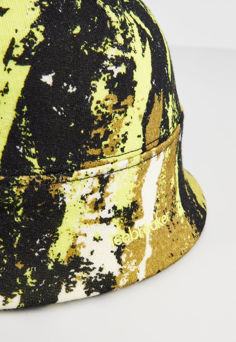Kapelusz typu bucket z abstrakcyjnym wzorem w kolorach czarnym, żółtym i brązowym. Wykonany z tkaniny o miękkiej fakturze, z wyszytym detalem z przodu.