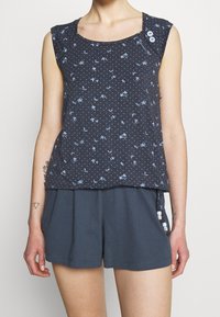 Navy sleeveless top with light blue floral pattern and dotted design. Features a rounded neckline and two buttons on the shoulder.