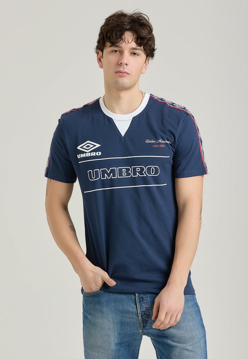 Mørkeblå kortærmet t-shirt med hvide detaljer og logo, der har en v-hals og striber ned ad ærmerne. Blødt bomuldsblandingsmateriale.