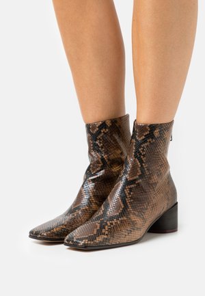Braun und schwarz Schlangenmuster-Ankle Boots mit spitzer Zehe und Blockabsatz. Glänzende Textur, angepasster Schaft und glattes Leder-Finish.