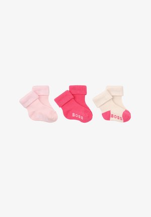 Trois paires de chaussettes pour bébé pliées en rose, rose foncé et crème avec des accents roses, chacune étiquetée avec le mot « Boss » sur le pied.