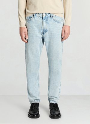Jeans in denim azzurro chiaro con design a gamba dritta e texture sbiadita. Presentano tasche frontali e chiusura con bottone, abbinati a scarpe nere.