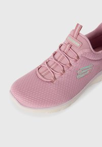 Pink athletic shoe featuring a breathable mesh upper, elastic laces, and a cushioned sole. Subtle "S" logo on the side.