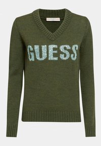 Pull-over en laine vert olive, avec un col en V, des manches longues et "GUESS" brodé en sequins bleu clair sur la poitrine.