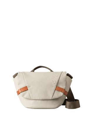 Borsa a spalla beige realizzata in tessuto resistente con una tracolla in pelle marrone. Presenta una forma strutturata e un manico superiore per il trasporto.