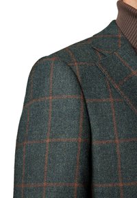 Zielona marynarka w kratę z brązowym wzorem. Posiada wyraźne ramiona, klapy w kształcie litery "notch" oraz teksturowane wykończenie.