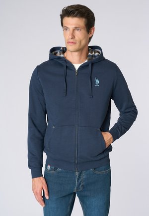Felpa con zip blu marina realizzata in un mix di cotone, con fodera interna a scacchi, dotata di zip frontale e due tasche laterali.