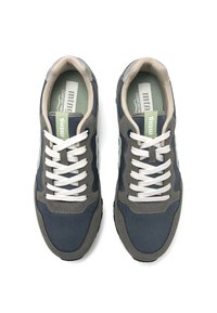 Zapatos deportivos en tonos azul oscuro y gris, fabricados con materiales de malla y gamuza, con cordones blancos y una plantilla acolchada marcados como "ajuste cómodo".