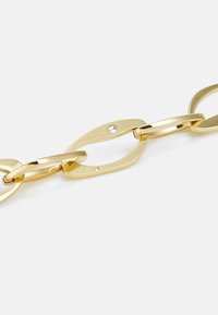 Bracelet en maillons dorés avec des formes ovales et allongées, finition polie et deux pierres gemmes transparentes encastrées.