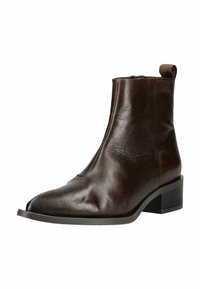 Stivale alla caviglia in pelle marrone con punta affusolata, texture liscia, linguetta sul retro e tacco basso a blocco. Dettaglio con zip sul lato.