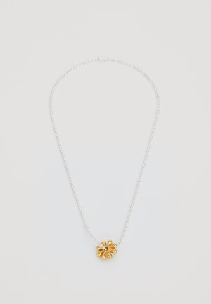 Collier en chaîne argentée avec un pendentif floral doré présentant des pétales incurvés et un détail en gemme central.